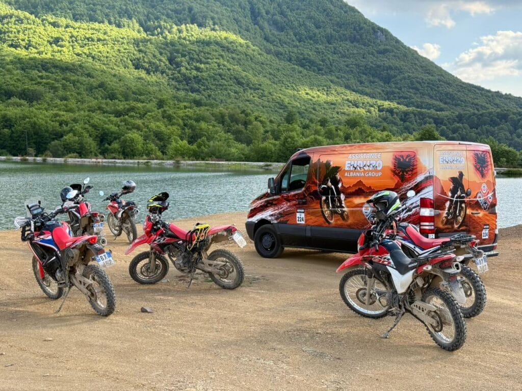 Vehículo de asistencia de Enduro Albania y motocicletas junto a un lago